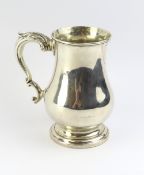 A silver tankard of typical form,