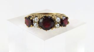 A 9ct gold garnet and split pearl ring, the centra