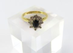 An 18ct gold sapphire and white stone cluster ring, th