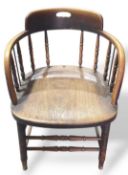 A short oak armchair with rounded arm rests suppor