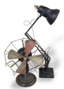 A black Anglepoise style lamp and a metal fan