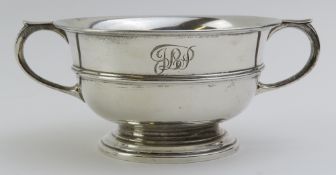 A silver porringer bowl with two curved handles, u