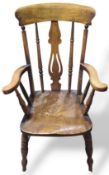 A wooden Windsor armchair with turned support feat