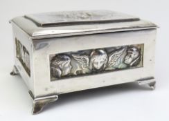 A decorative silver box on four corner feet; the o