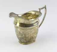 A silver milk jug with smooth body and crusted rim