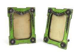 A pair of enamel silver picture frames set with si
