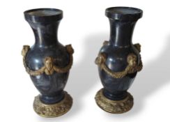 A pair of heavy black hardstone urns or garnitures