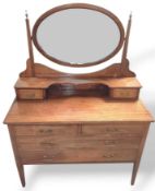 A mahogany dressing table with oval mirror on a st