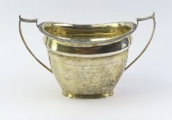 A silver sugar bowl with smooth body and crusted r