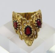 A gold garnet set ring, marked ‘14K’, the three ov