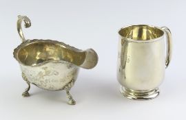 A silver cream jug alongside a silver christening