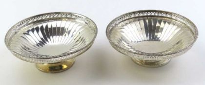 A pair of silver dishes with engraved petalled features