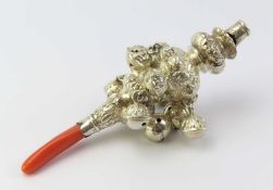 A Victorian silver rattle with red coral handle