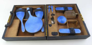A styled dressing set in bespoke case, the items with silver and enamel accents