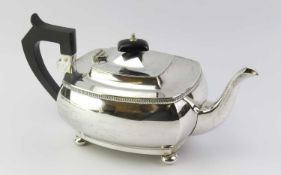 A silver teapot consisting of four convex panels