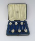 A cased set of six silver coffee spoons with ebonised bean finials