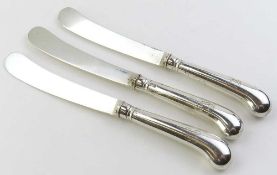 Three silver butter knives with silver handles and blades