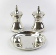 A cased silver salt pot, pepper pot and circular dish