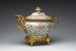 A Chinese Canton famille rose gilt mounted tureen and cover with animated scenes resting on four ele