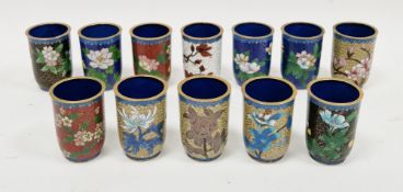 Twelve 20th century Chinese cloisonne cylindrical beakers, variously inlaid with flowers on coloured