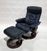 Stressless reclining armchair on circular supports upholstered in blue leather, with footstool