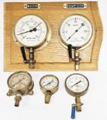Early 20th century brass cased altitude gauge and vacuum gauge mounted on a wooden plinth, with