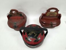Two Chinese red lacquered and metal bound wedding baskets, one of oval form and the other of round