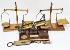 Set of early 20th century brass postal scales, two sets of gilt brass balance scales with weights,