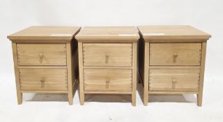 Three modern matching pale oak bedside cabinets, each of rectangular form with two drawers and oak