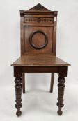 19th century mahogany hall chair, the solid back with arched carved top rail, solid seat, on