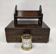 French brass cased carriage clock of oval form, the white enamel face with roman numerals and rubbed