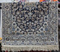Persian-style midnight blue ground rug with central floral motif, floral spandrels, multiple