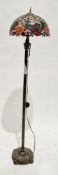 Tiffany-style standard floor lamp with a floral patterned leaded glass shade, on a metal