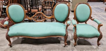 Victorian walnut-framed settee and matching armchair, the settee with central foliate scroll splat