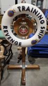 Lifebuoy from Royal Navy training ship ' Revenge ', mounted on a wooden cruciform stand, the