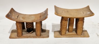 Two early 20th century African Ashanti wooden stools, each with curved seat, central columns