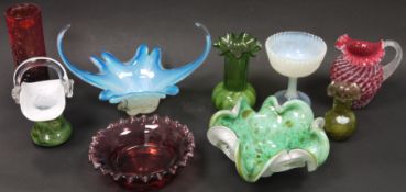 A collection of coloured glassware including: a Fenton cranberry and opalescent hobnail moulded