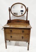 Edwardian oak dressing chest, having an oval bevelled edge swing mirror over two long drawers with