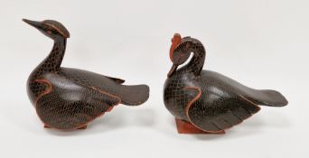 Two Asian carved wooden models of birds / ornamental ducks, having a black and red lacquered finish,
