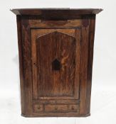 George III oak and mahogany hanging corner cabinet, the single panel door opening to two shaped