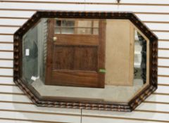 Early 20th century octagonal wall mirror, the bevelled edged plate in an oak carved frame, 83cm x