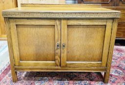 Early 20th century oak matching cupboard and dressing chest, both with greek key carved frieze,