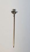 Late 19th/early 20th century white metal stickpin, the head in the form of a flower, claw set with
