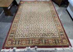 Large cream ground carpet, the central panel with a floral pattern, within a red ground border