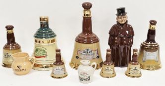 Collection of Bell's Whisky decanters in sizes, including three miniatures, a pottery coachman