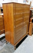 Mid-century Alfred Cox teak wardrobe, comprising two panel doors with gilt metal loop handles