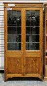 1930's/40's oak display cabinet having two glazed leaded doors, opening to three adjustable glass