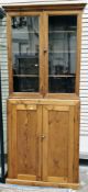 19th/early 20th century pine cupboard, the upper section with two glazed doors opening to three