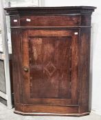 George III oak wall-mounted corner cupboard, flat-fronted with two shaped shelves and fluted side
