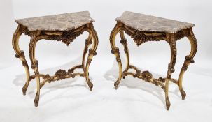 Pair of Louis XV-style console tables, the shaped marble tops over foliate scrolling decoration, the